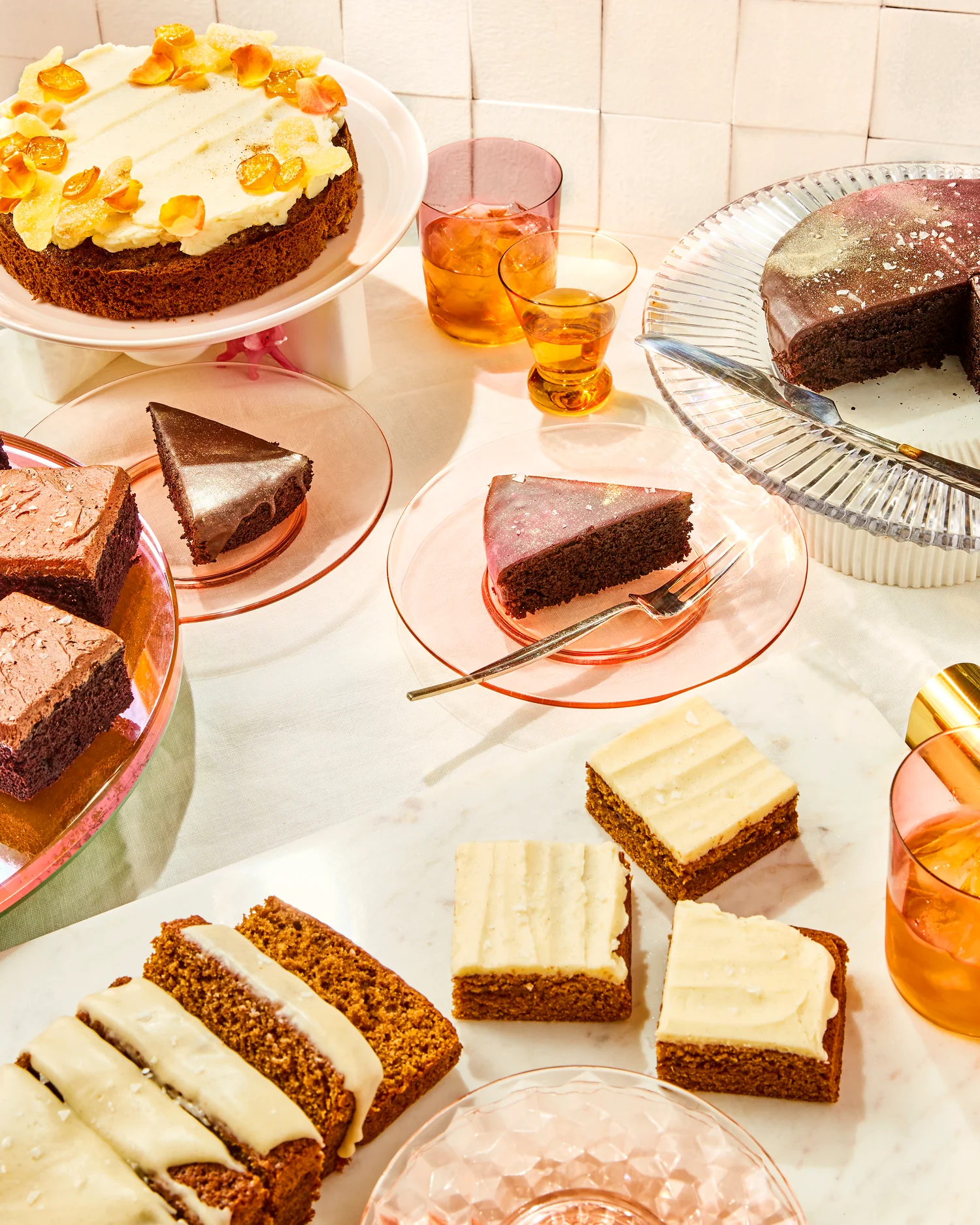 A picture of an array of cakes and drinks on a table